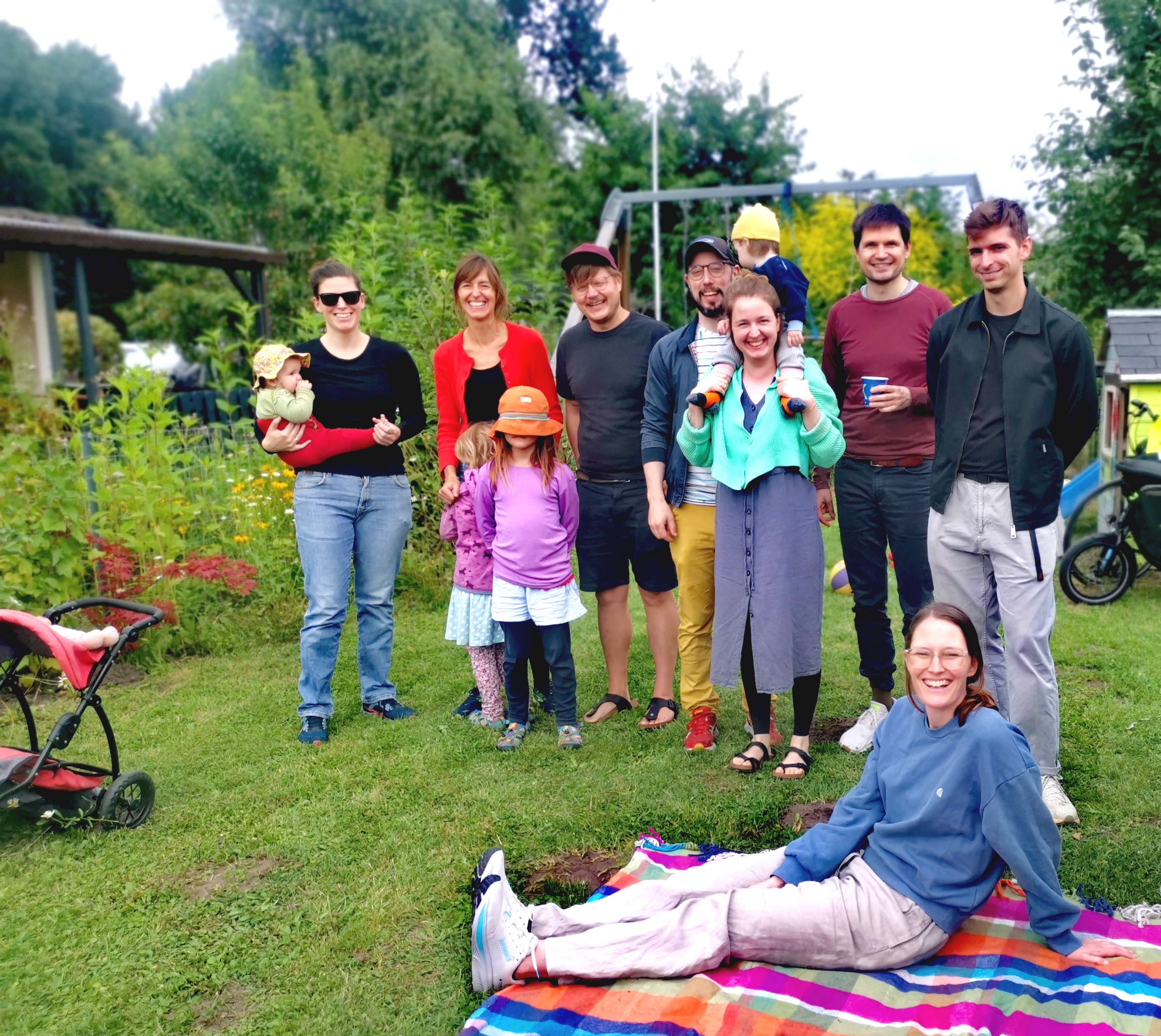 Mitglieder der Baugemeinschaft Kupferdiek stehen auf einer Wiese zusammen.